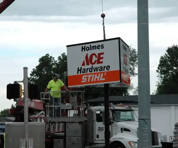 Crew installing the new Holmes Ace Hardware sign in New Albany